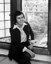 Photograph of Phyllis Trible, a young dark-haired woman kneeling in front of an open window overlooking the Union Theological Seminary courtyard