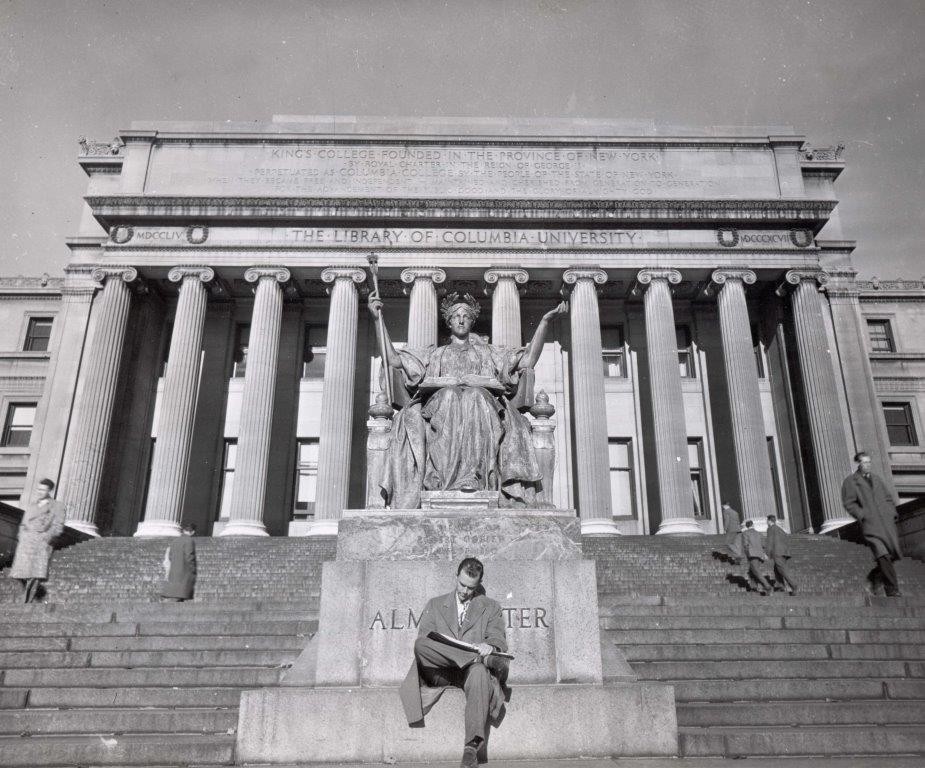Man sitting in front of Alma Mater statue.