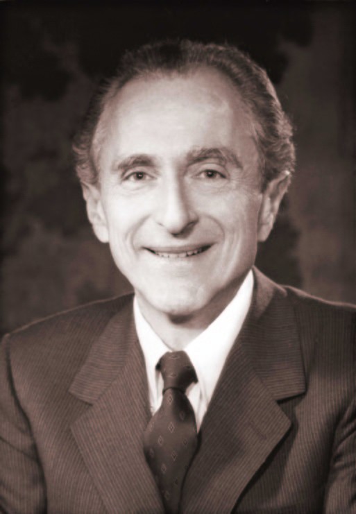 black and white portrait photo of David Hamburg in a suit, smiling