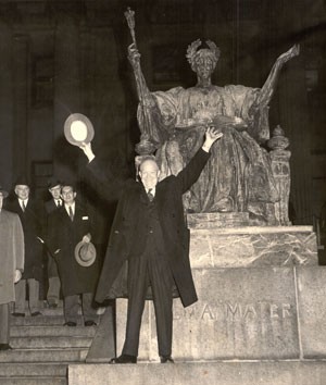 Photo of Dwight Eisenhower with arms raised in front of Alma Mater statue